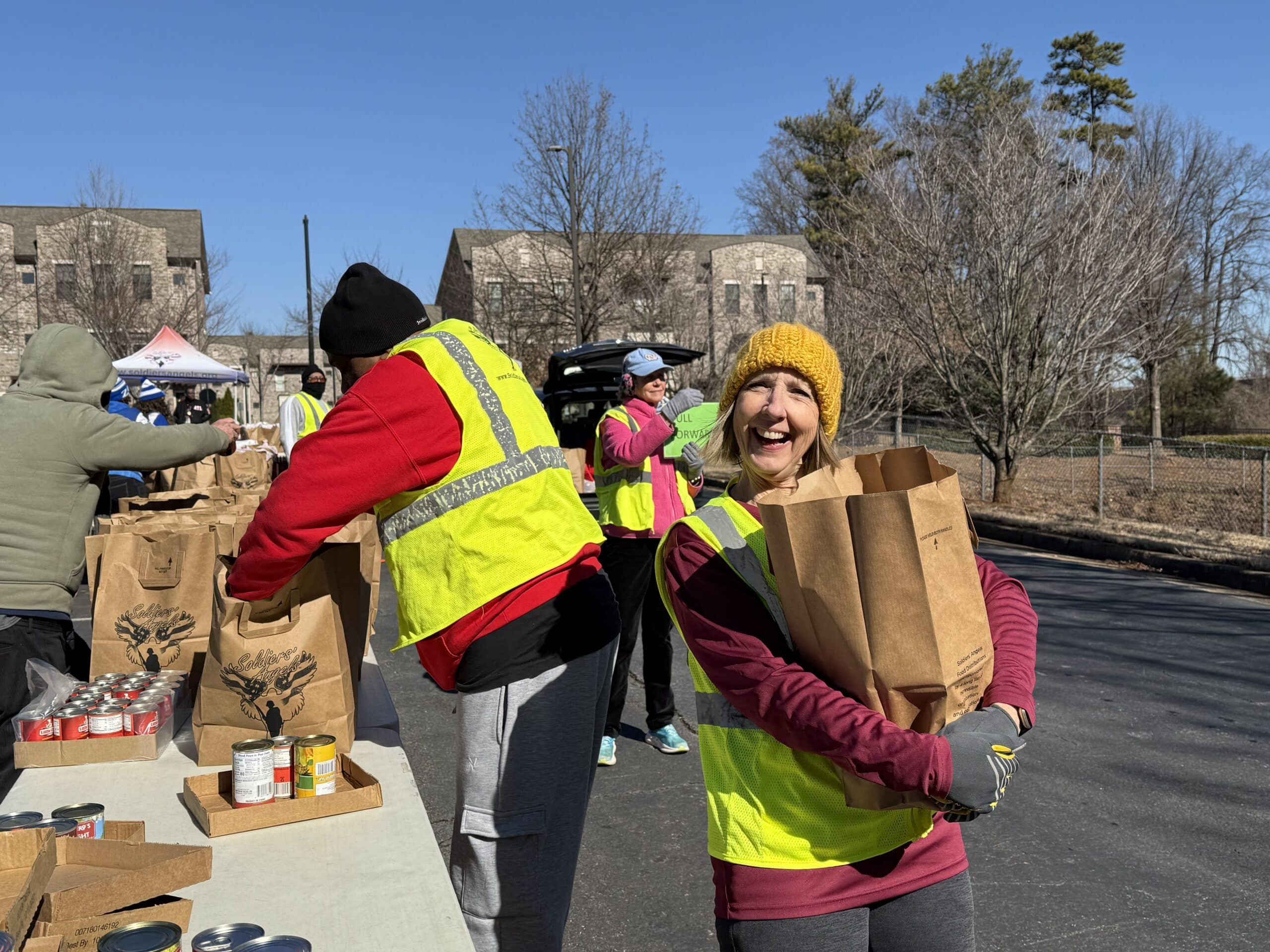 Volunteers distributing food to service members and veterans at an outdoor event
