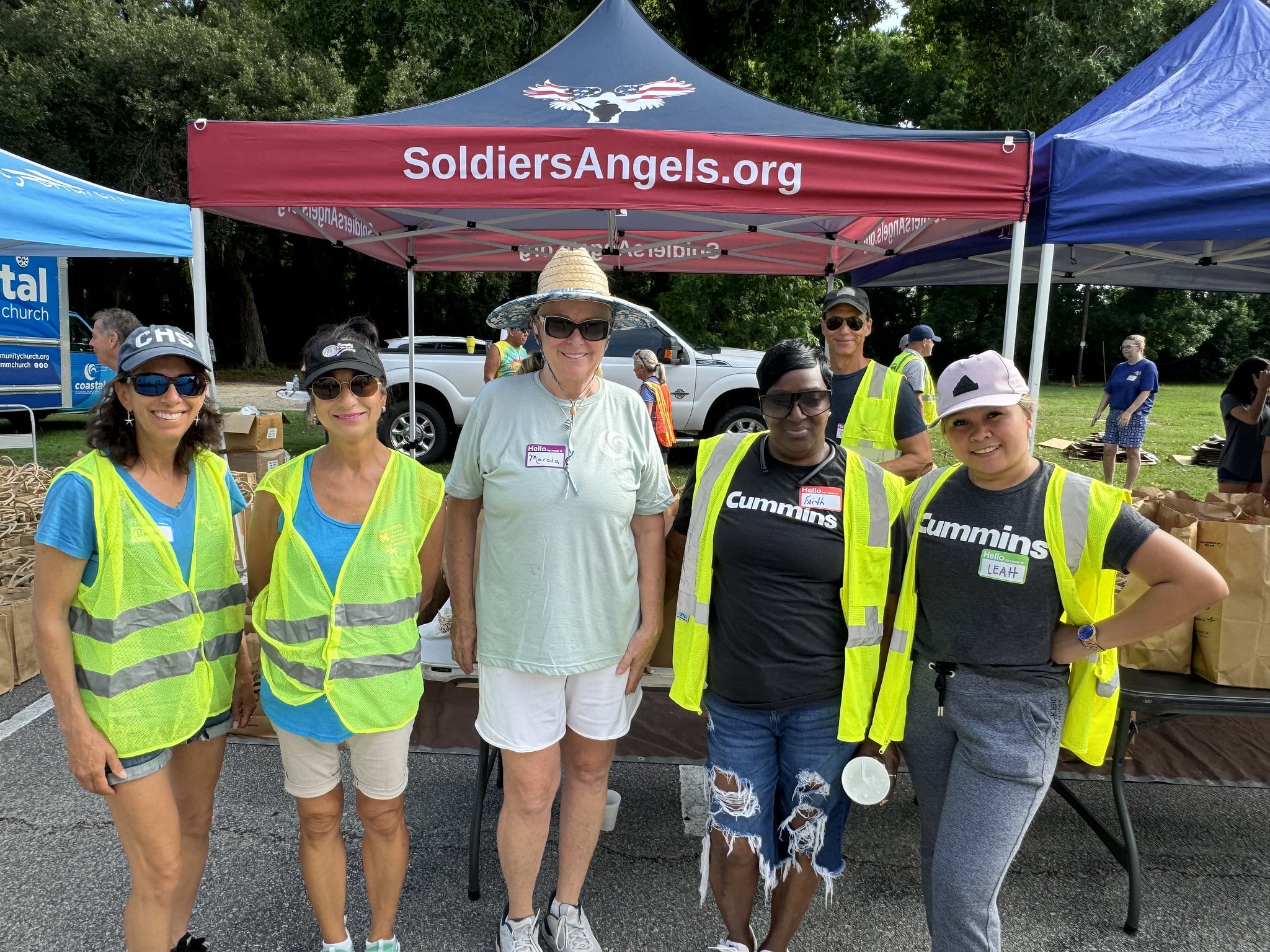 Soldiers' Angels volunteers in red shirts posing outdoors at a food distribution event in Atlanta, Georgia