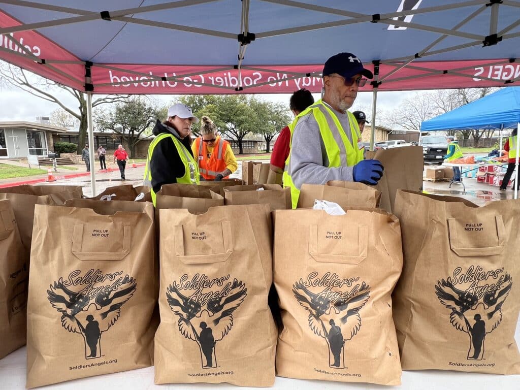 Soldiers' Angels volunteers handing out food boxes at an event